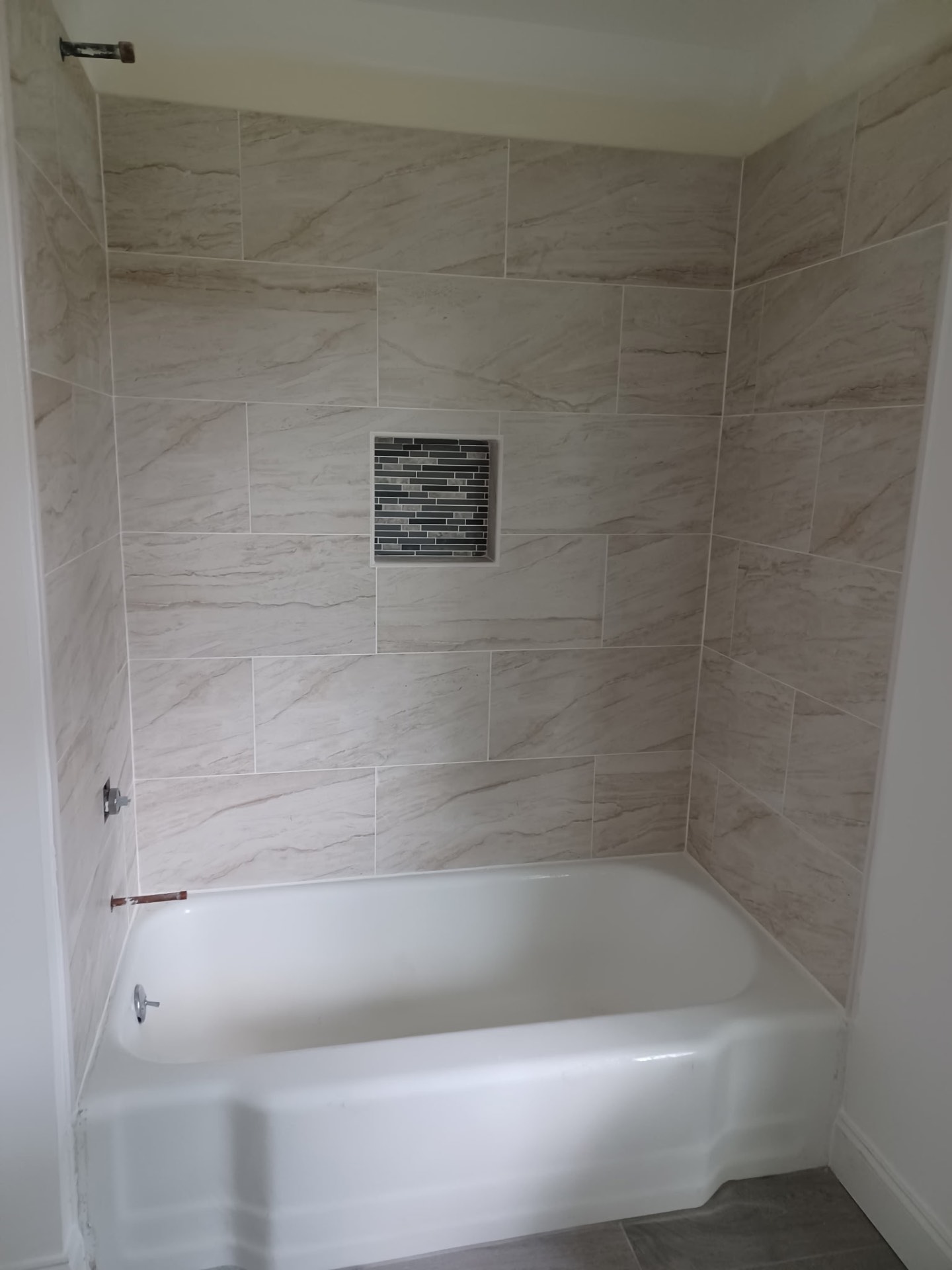 Tub surround tile with mosaic niche